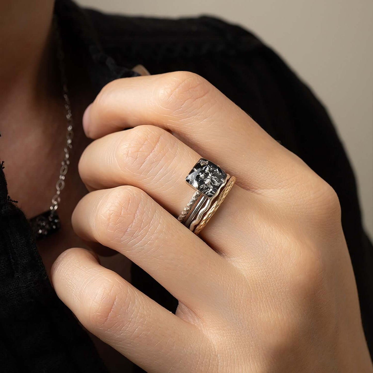 Close-up of a hand wearing a diamond ring with a blurred background