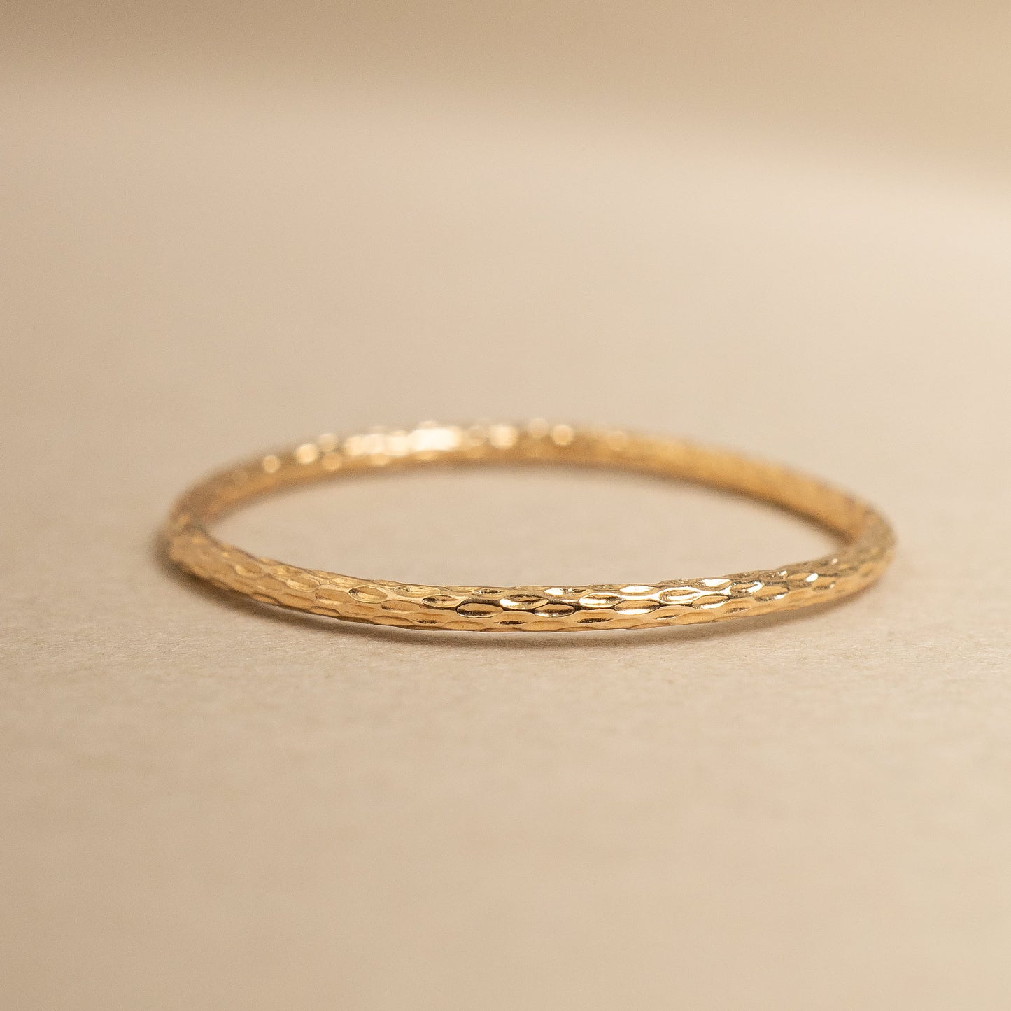 Gold ring on a beige background