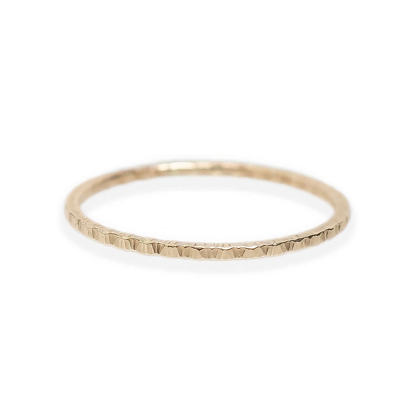 Gold ring with a textured band on a white background