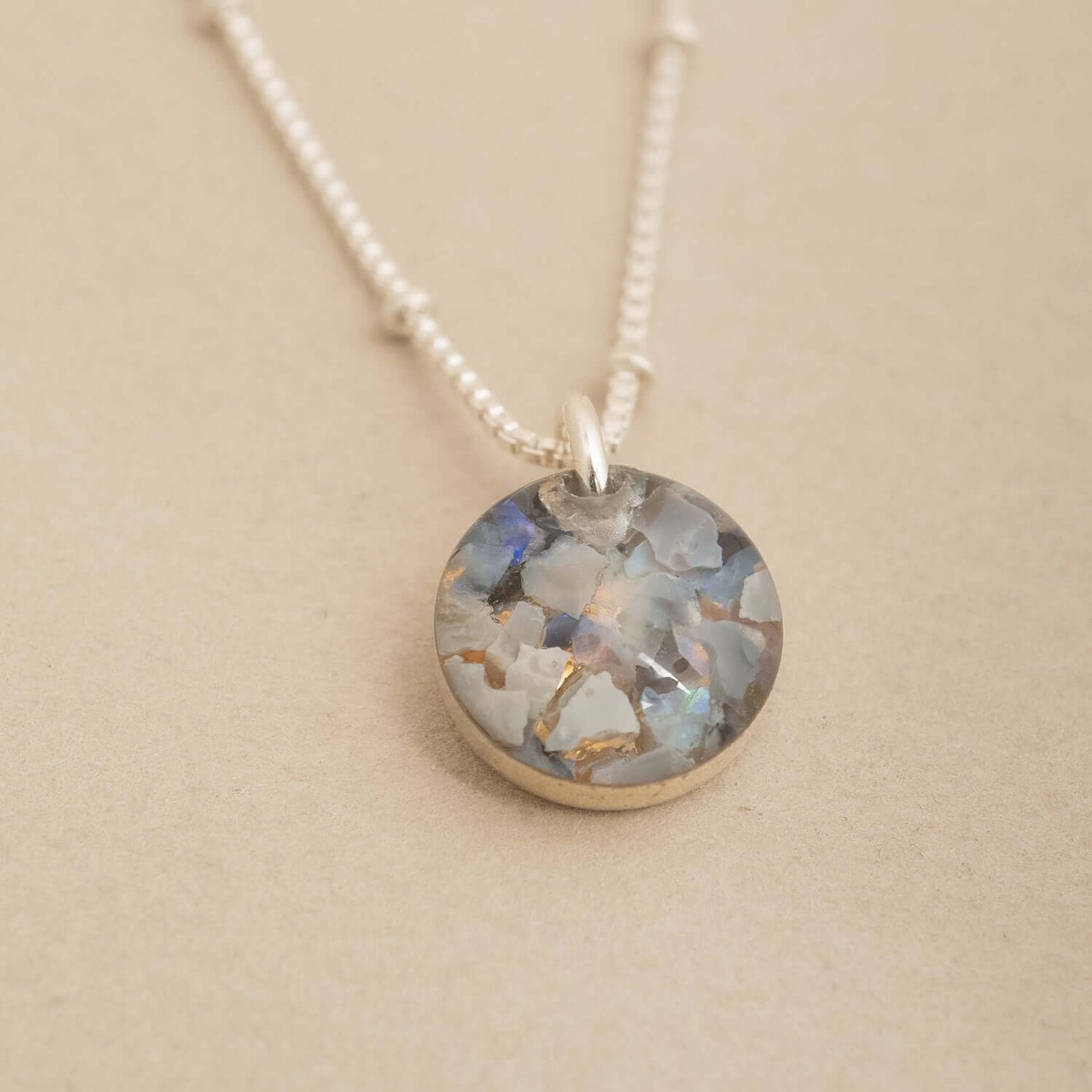 Necklace with a round pendant on a beige background