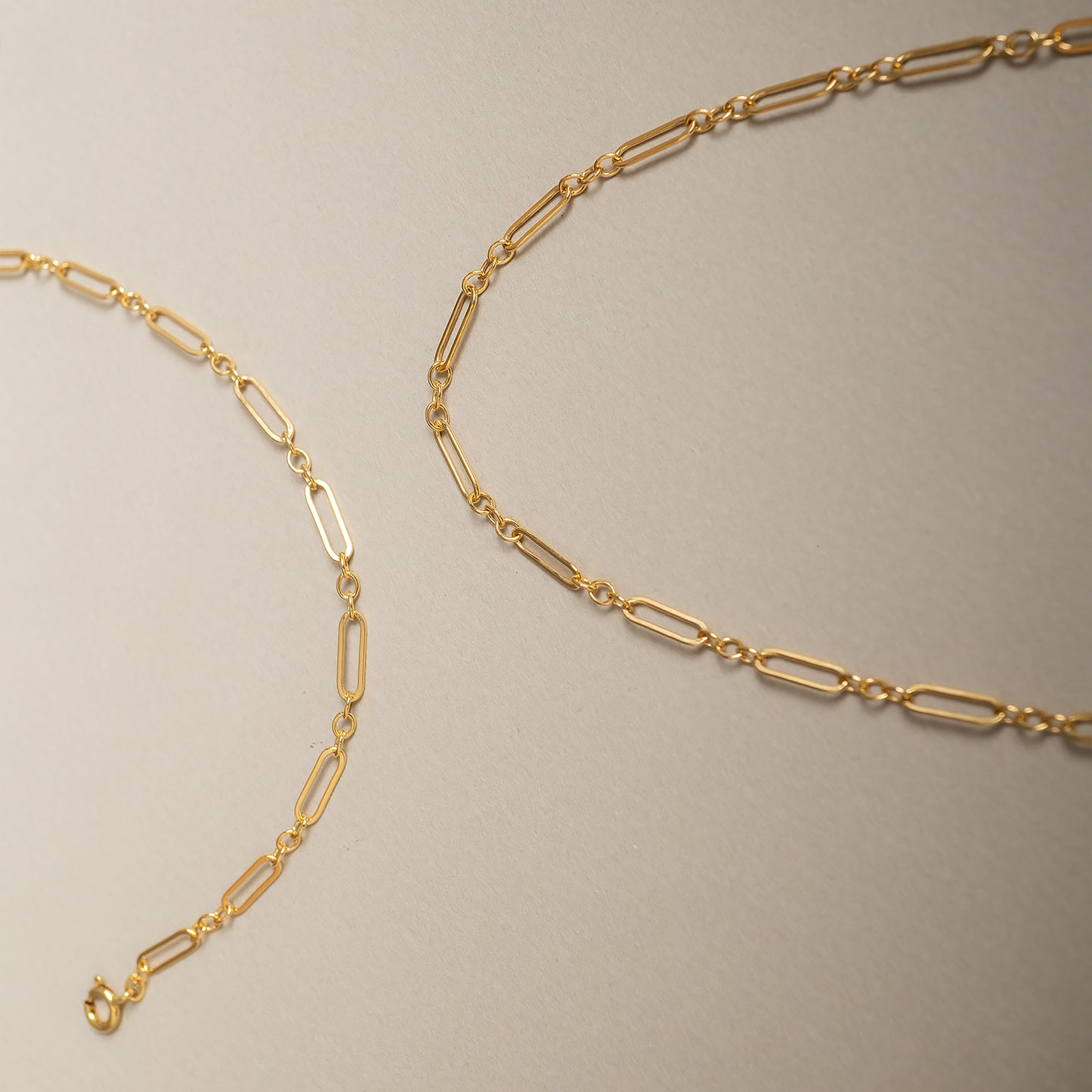 Gold chain necklace on a beige background