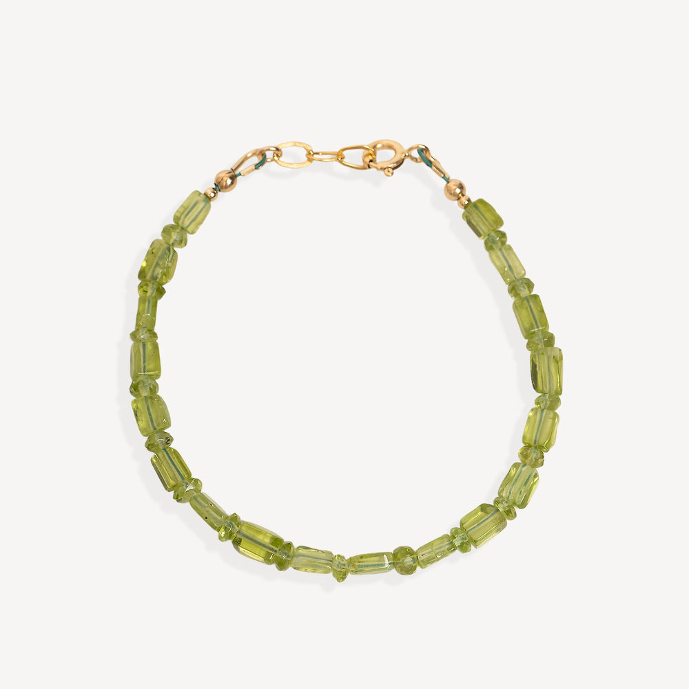 A beaded bracelet made of faceted olive green beads with a gold-tone clasp, shown on a light gray background.