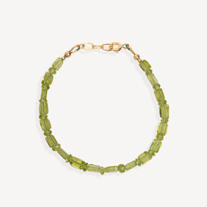 A beaded bracelet made of faceted olive green beads with a gold-tone clasp, shown on a light gray background.