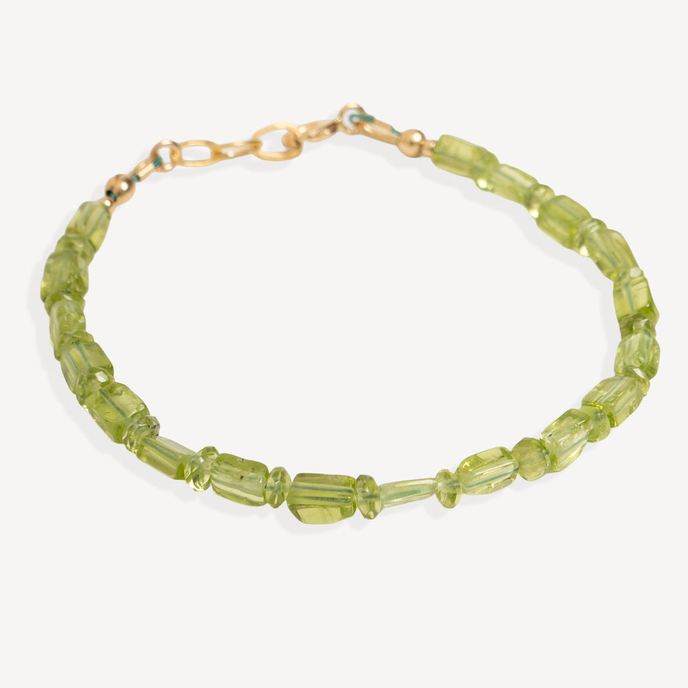A beaded bracelet made of faceted olive green beads with a gold-tone clasp, shown on a light gray background.