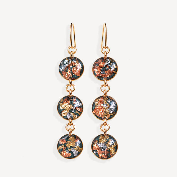 A pair of gold-tone dangle earrings with three circular glass disc charms each featuring a colorful metallic foil pattern of copper, gold, and silver on a dark background, set against a plain off-white background.