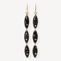 Pair of black and gold earrings on a white background