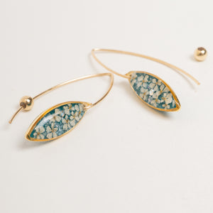 Gold hoop earrings with marquise-shaped dangles featuring a teal and cream marbled pattern, displayed on a clean off-white background.