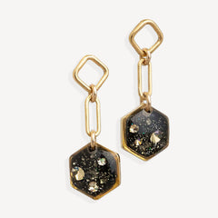 Gold and black hexagonal earrings on a white background