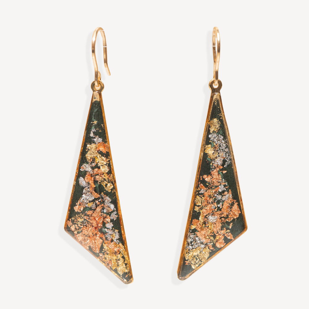 A pair of gold-tone geometric drop earrings with triangular pendants featuring a dark green background and a textured, metallic orange, gold, and silver inlay, shown against a plain off-white background.