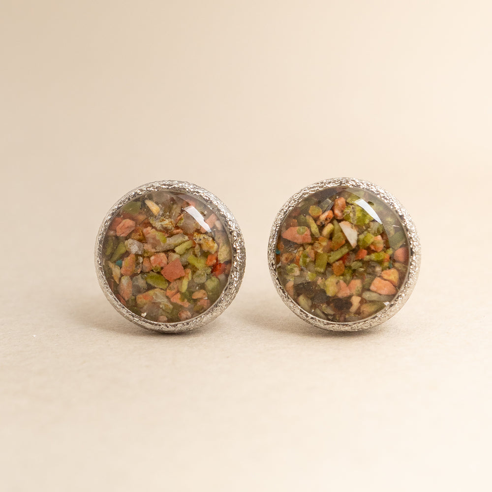 
                      
                        Round earrings with embedded stones on a beige background
                      
                    