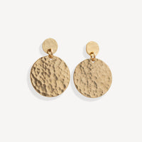 Gold earrings with a textured round design on a white background
