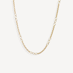 A delicate gold chain necklace with elongated oval links, displayed in a curved shape against a clean, off-white background.