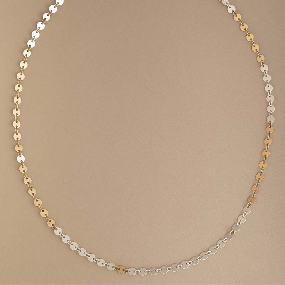 
                      
                        Necklace with gold and silver beads on a beige background
                      
                    