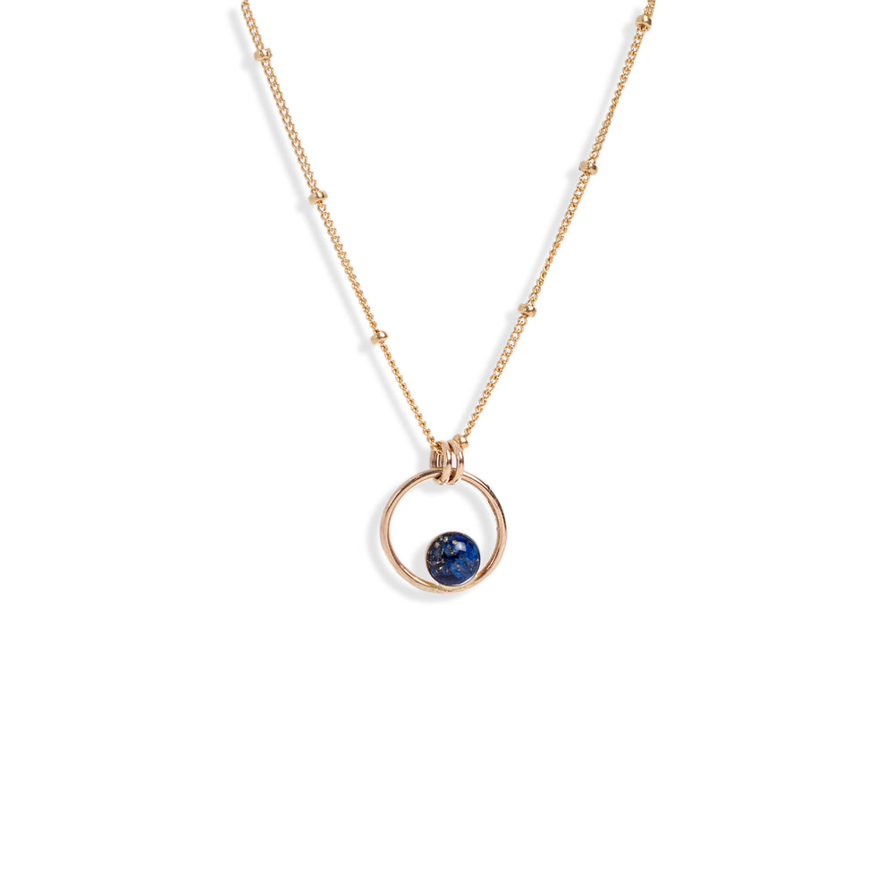 
                  
                    Tiny Blue Lapis Orbit Necklace with crushed natural Lapis stone pieces captured in glass like resin. 
                  
                