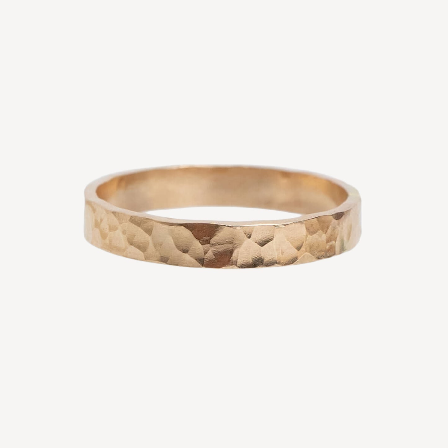 Gold ring with a textured surface on a white background