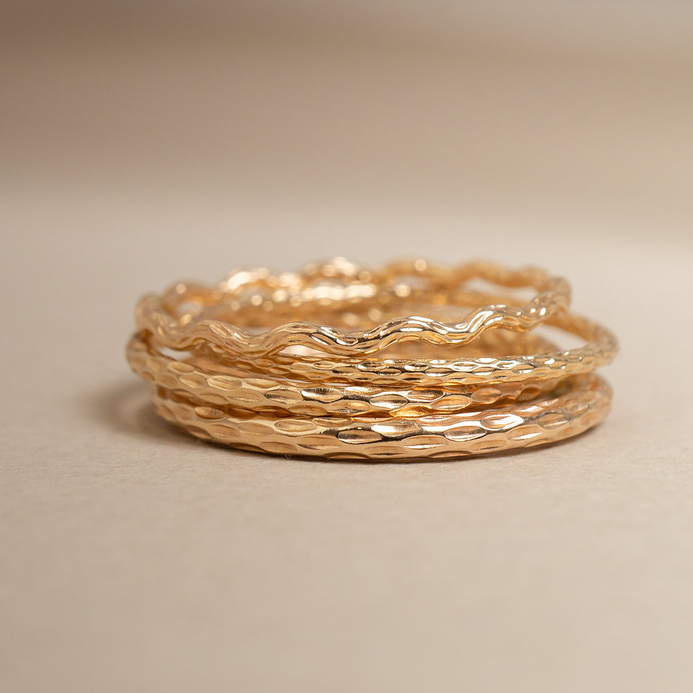 Stack of gold rings on a beige background