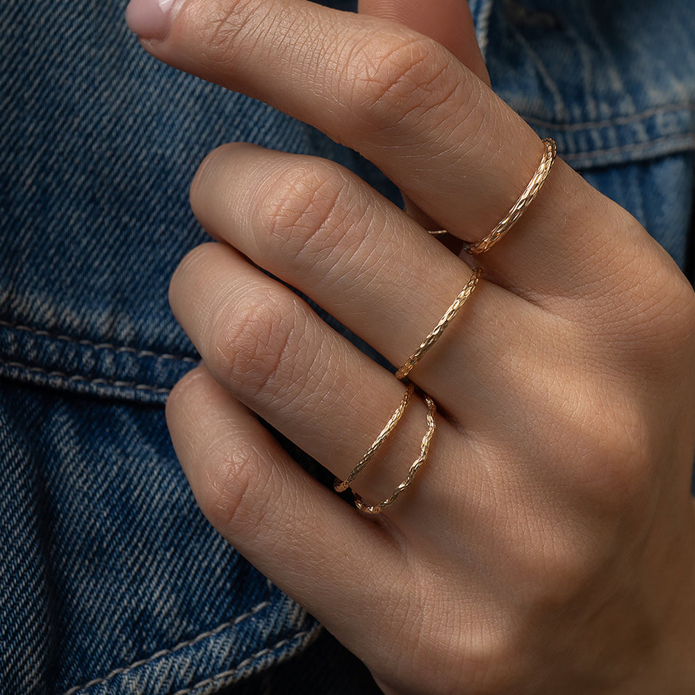 
                      
                        Hand wearing two gold rings with a denim background
                      
                    
