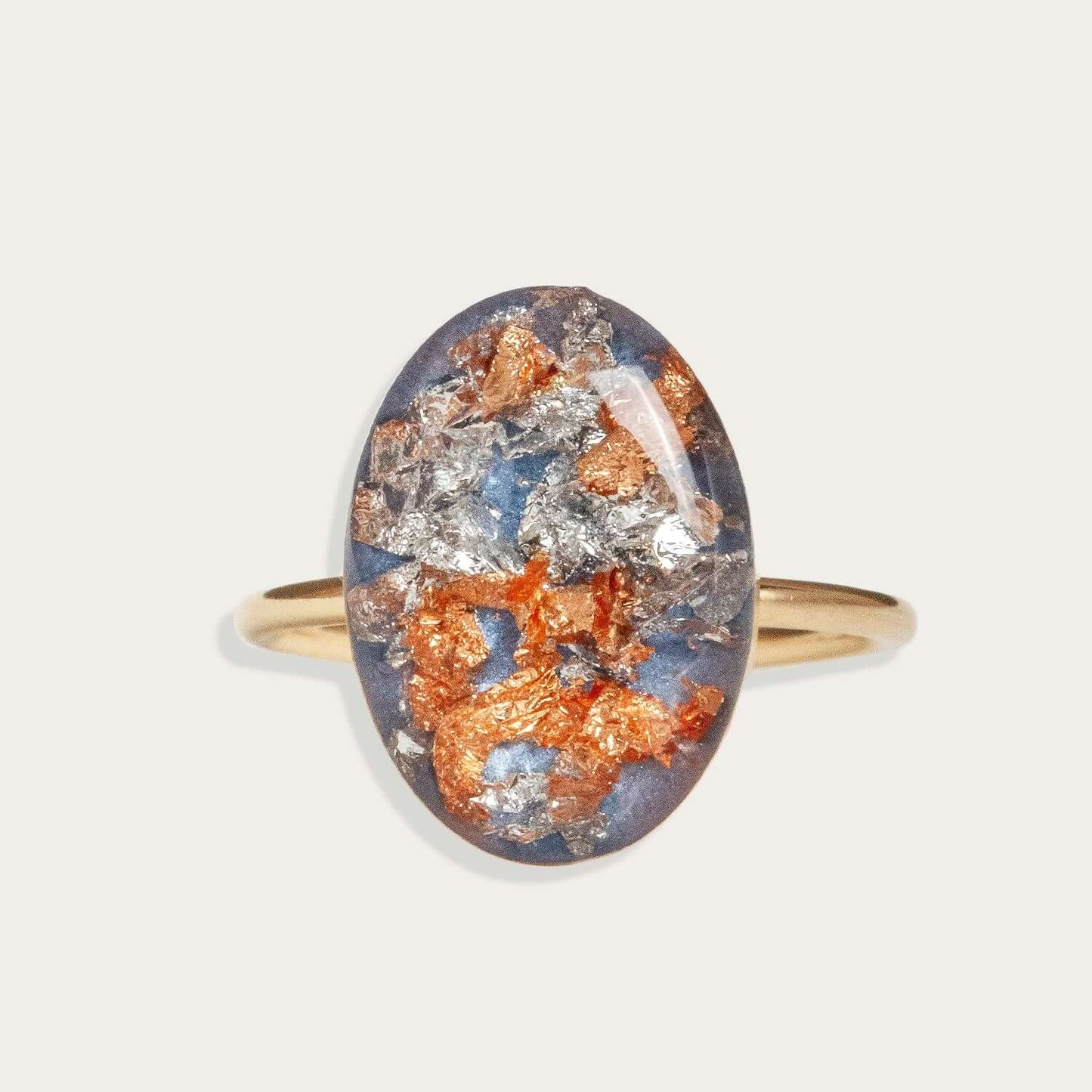 Ring with an oval stone featuring orange and silver colors on a light gray background