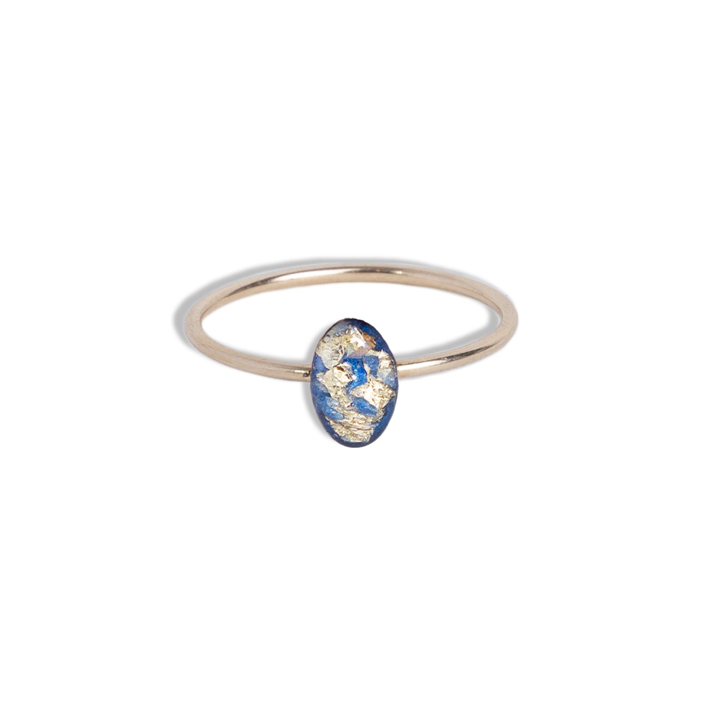 
                  
                    Tiny Blue and Gold Oval Ring with gold leaf on a bright blue background sealed in a glass-like resin crystal.
                  
                