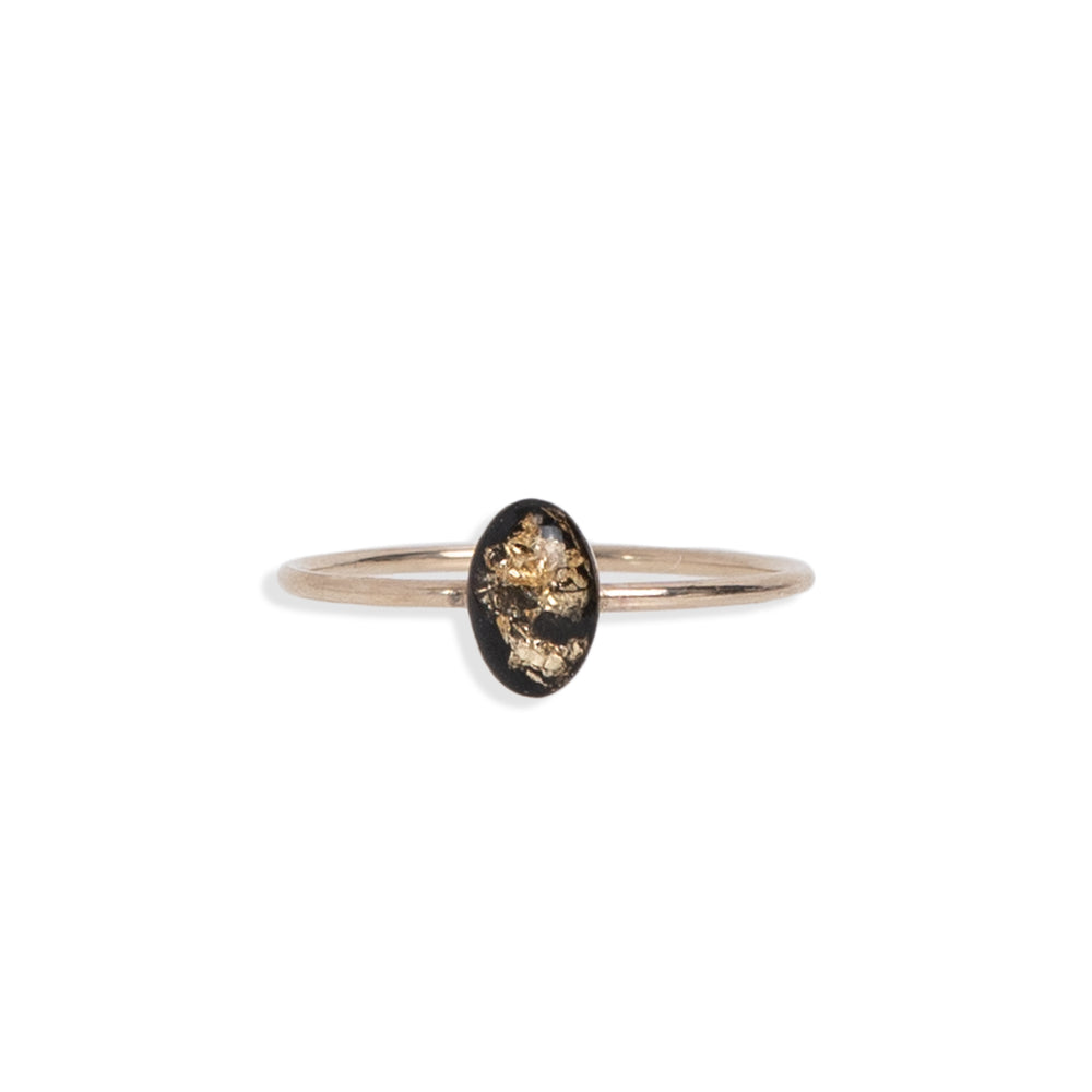 
                  
                    Tiny Black and Gold Oval Ring with gold leaf on a black background sealed in a glass-like resin crystal.
                  
                