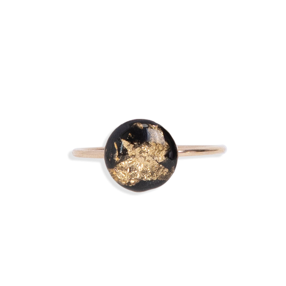 
                  
                    Black and Gold Round Ring with gold leaf on a black background sealed in a glass-like resin crystal.
                  
                