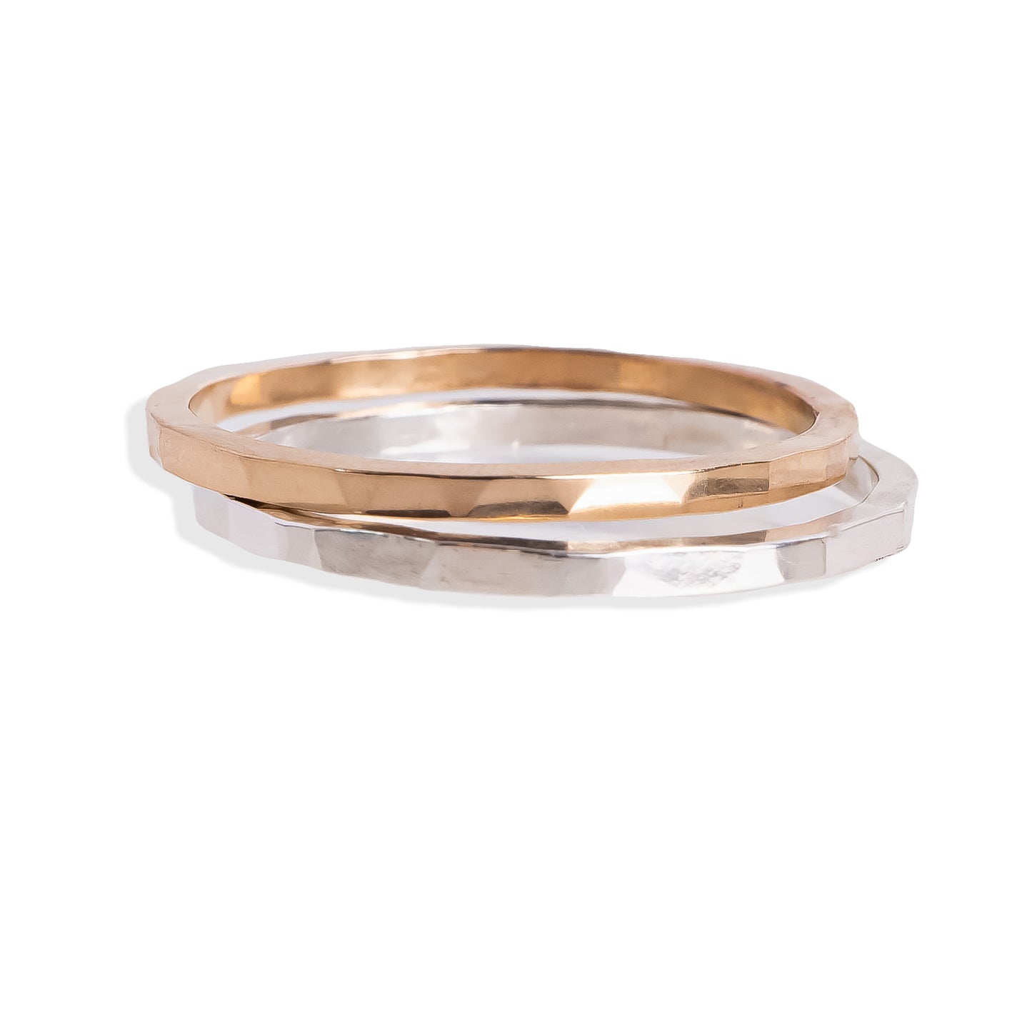 Two gold and silver rings stacked on a white background