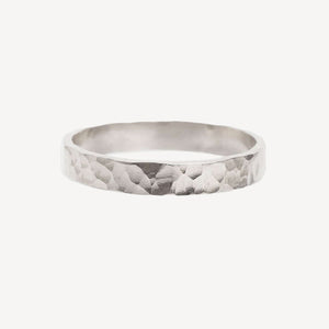 Silver ring with a textured pattern on a white background