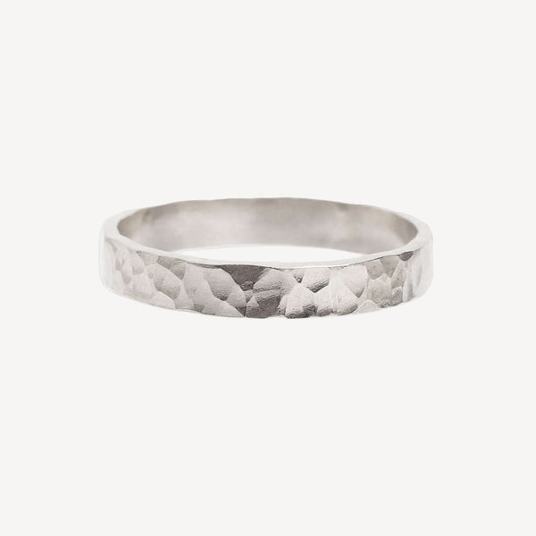 Silver ring with a textured pattern on a white background