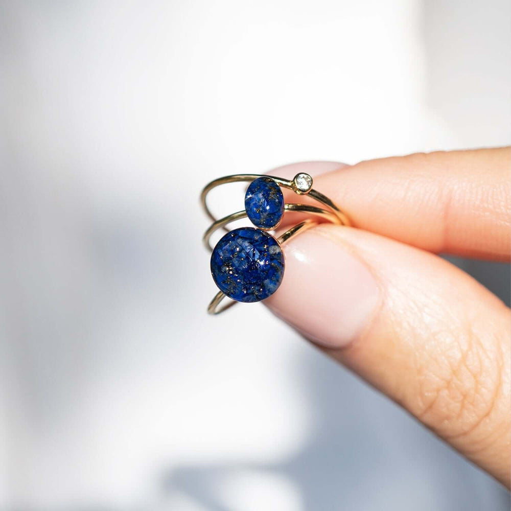 Gold ring with a blue stone on a white background