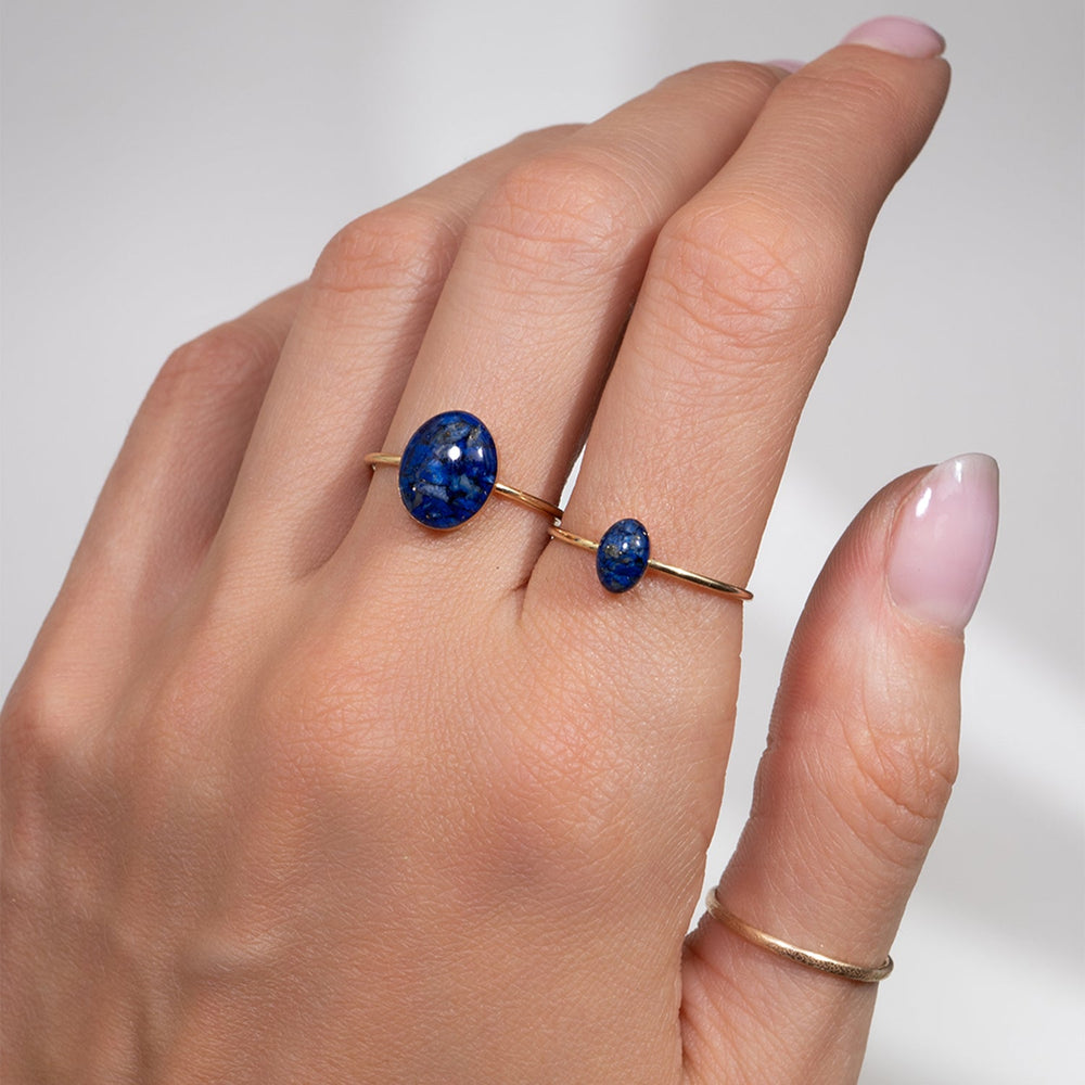 Gold ring with a blue stone on a white background