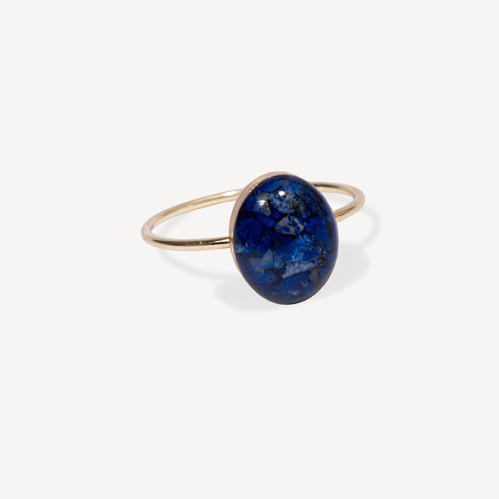 Gold ring with a blue stone on a white background