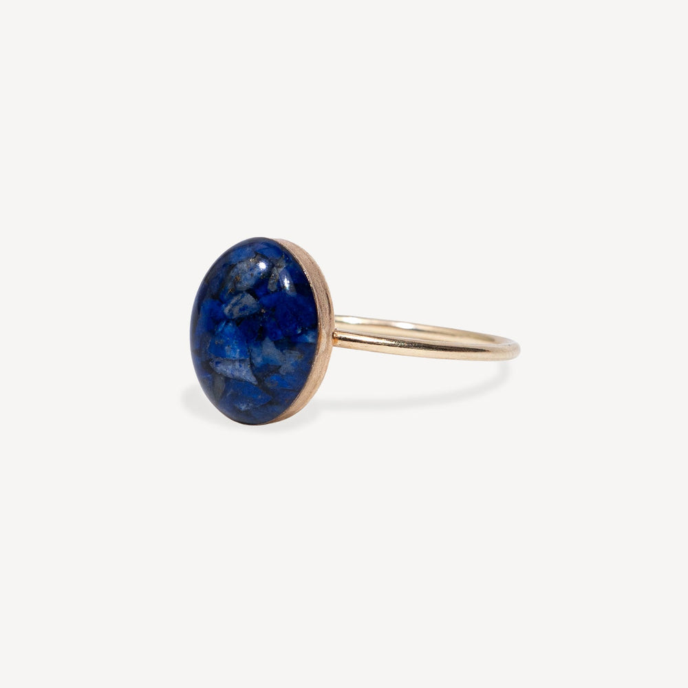 Gold ring with a blue stone on a white background