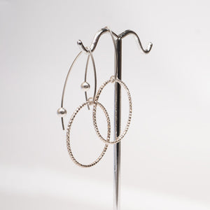 Handcrafted gold-filled disco hoop dangle earrings with textured reflective surface by Kate Koel