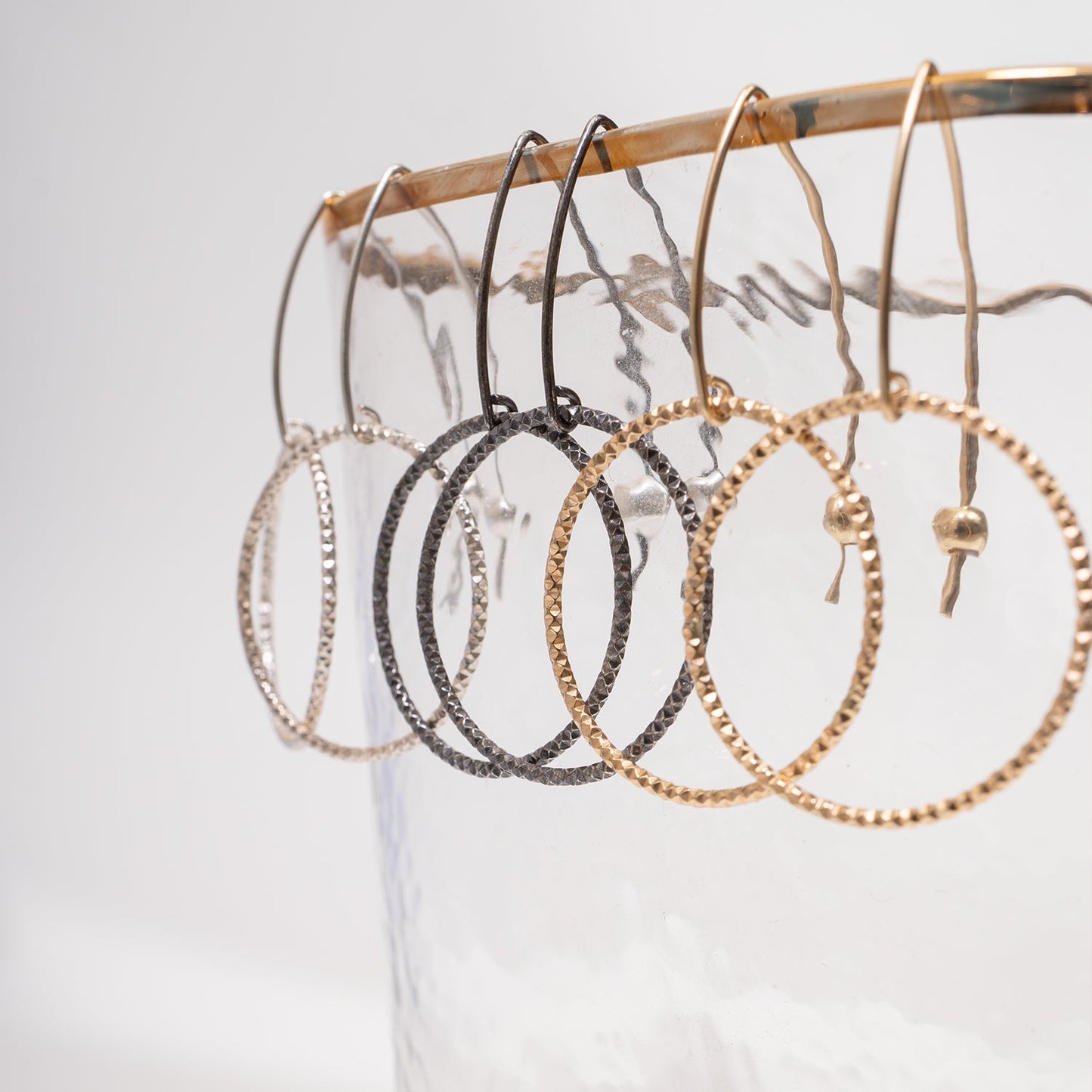 Handcrafted gold-filled disco hoop dangle earrings with textured reflective surface by Kate Koel