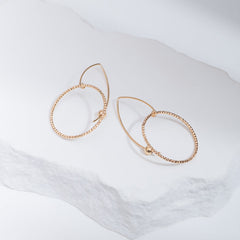 Handcrafted gold-filled disco hoop dangle earrings with textured reflective surface by Kate Koel