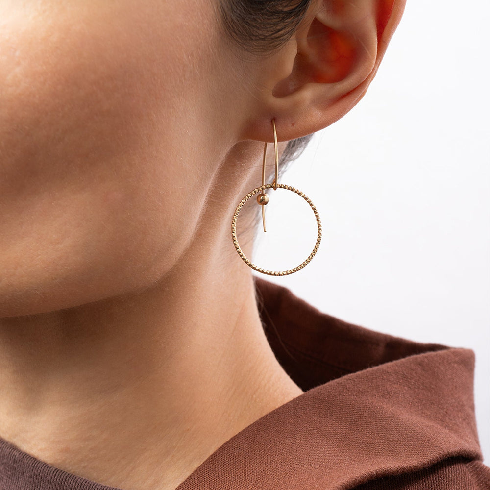 Handcrafted gold-filled disco hoop dangle earrings with textured reflective surface by Kate Koel