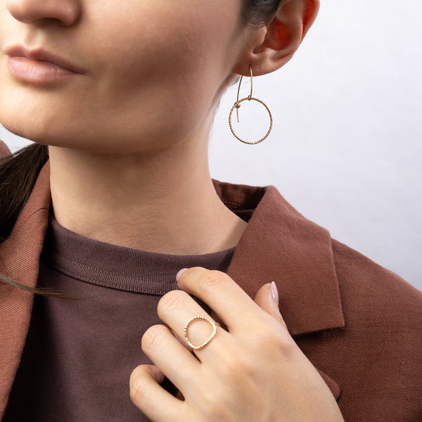 Handcrafted gold-filled disco hoop dangle earrings with textured reflective surface by Kate Koel