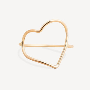 A delicate gold open heart cuff ring with a polished finish, displayed on a clean, light off-white background.