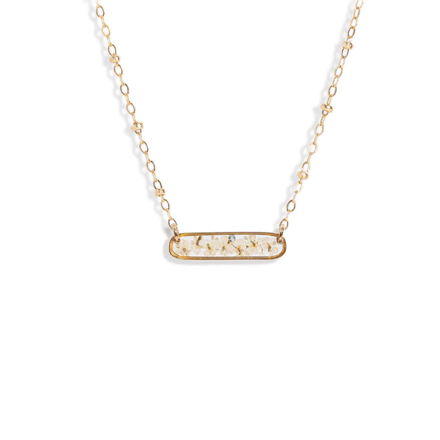 Long bar pressed flower necklace in gold-plated brass
frame with 14k gold filled chain handmade by Kate
Koel