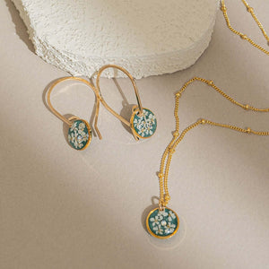 Handcrafted minimalist floral hoop earrings with delicate flower accent in gold-filled metal by Kate Koel
