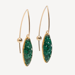 Gold earrings with green gemstones on a white background