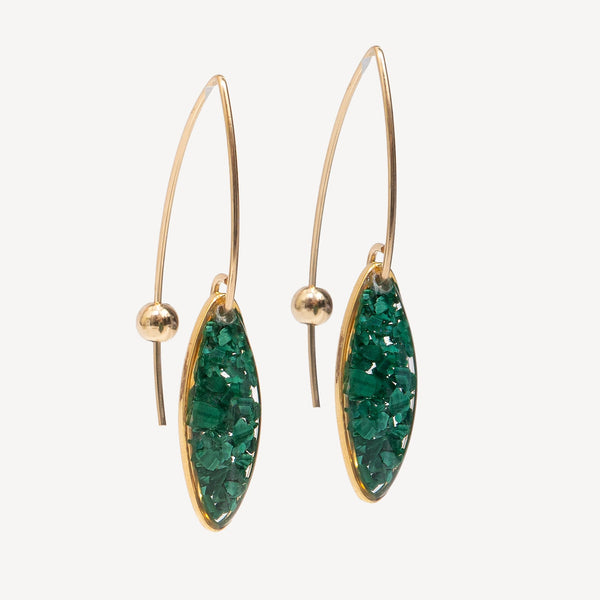 Gold earrings with green gemstones on a white background