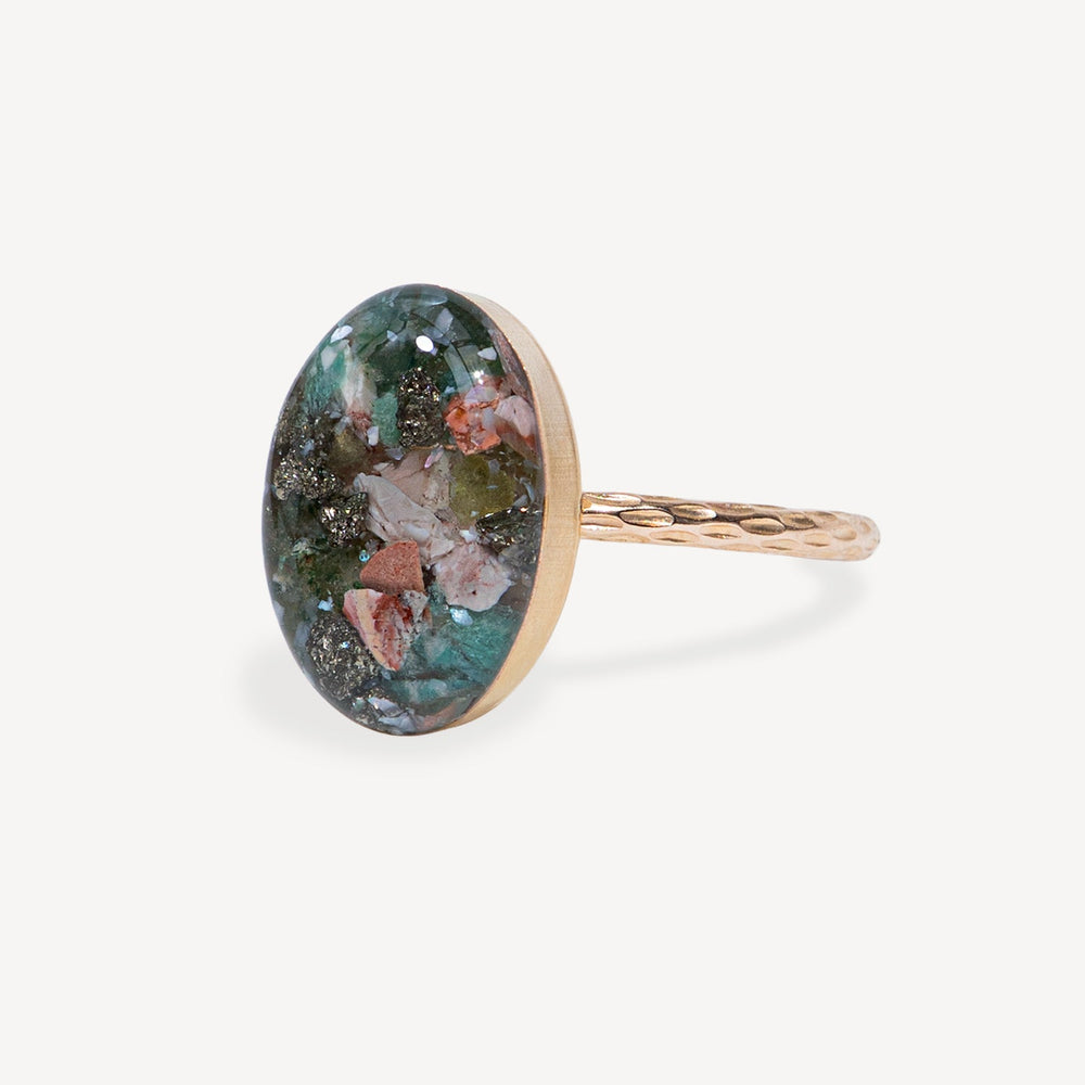 Ring with a colorful oval stone on a white background