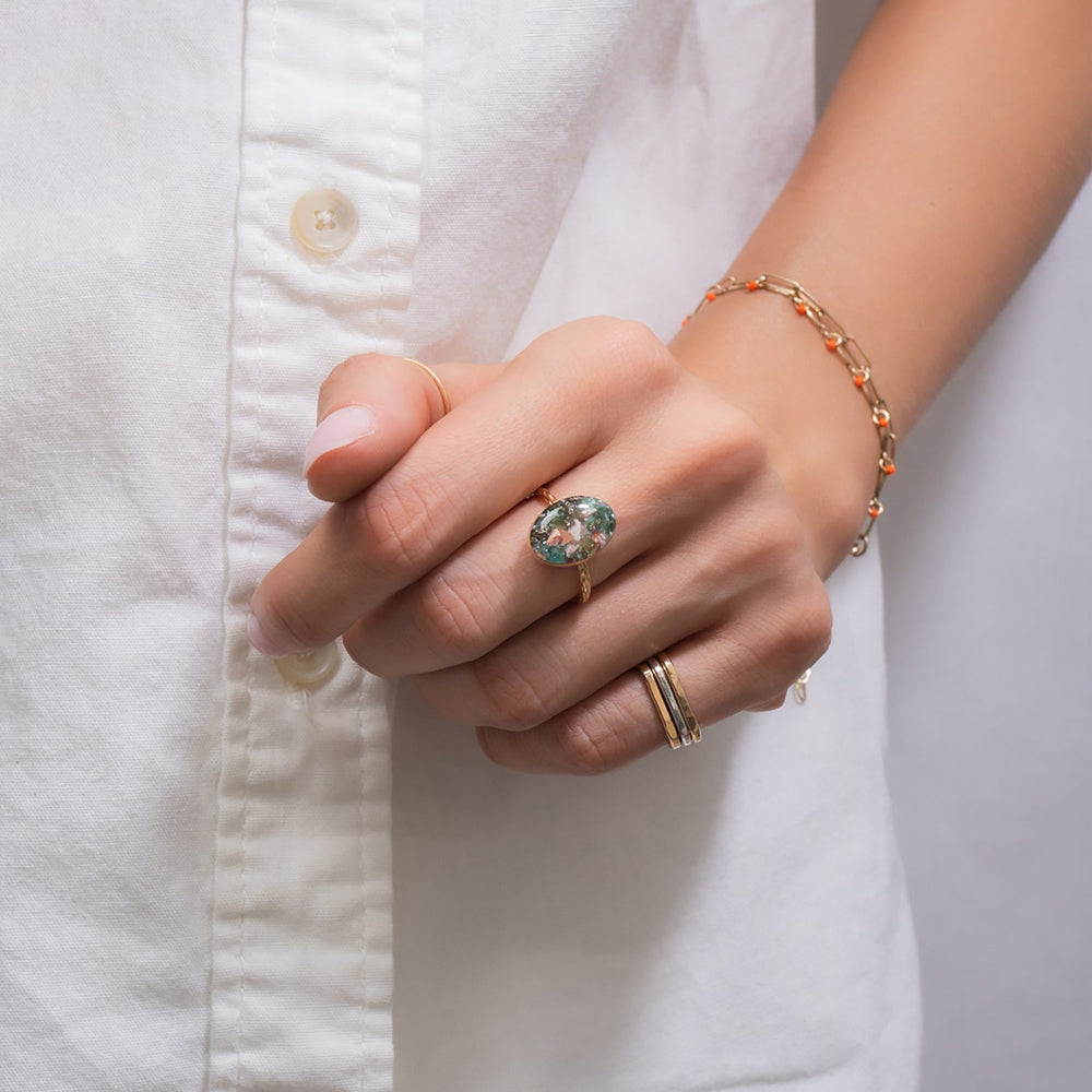 Ring with a colorful oval stone on a white background