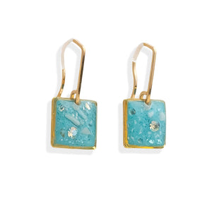 Pair of earrings with turquoise square stones and gold accents on a white background