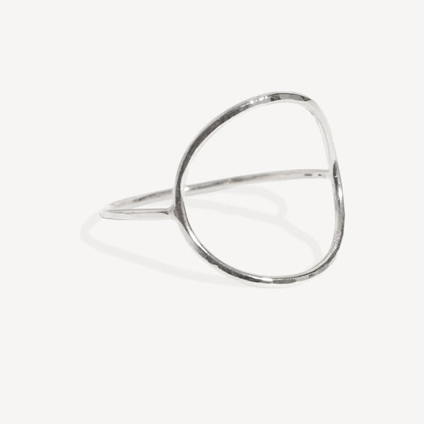 A minimalist silver open ring bangle with a polished, hammered texture, displayed on a clean off-white background.