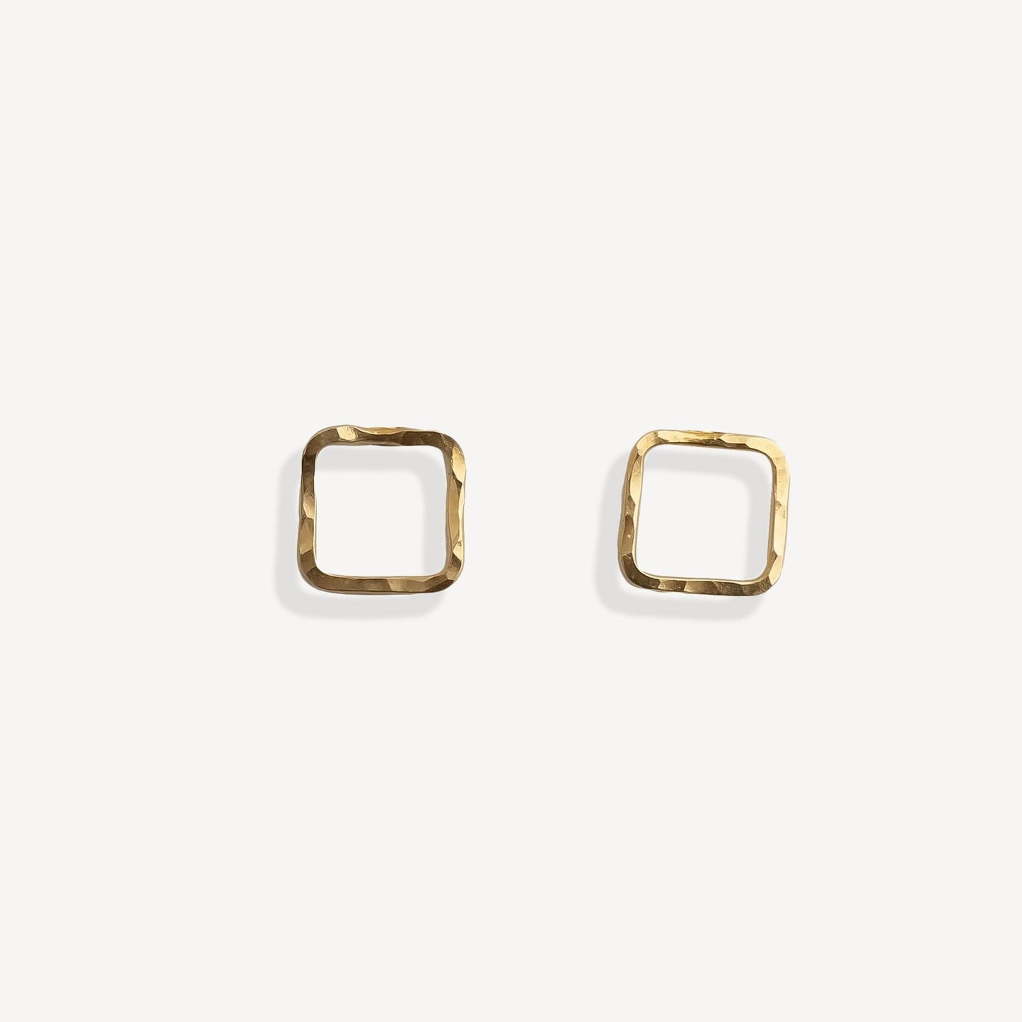 Gold square stud earrings on a white background