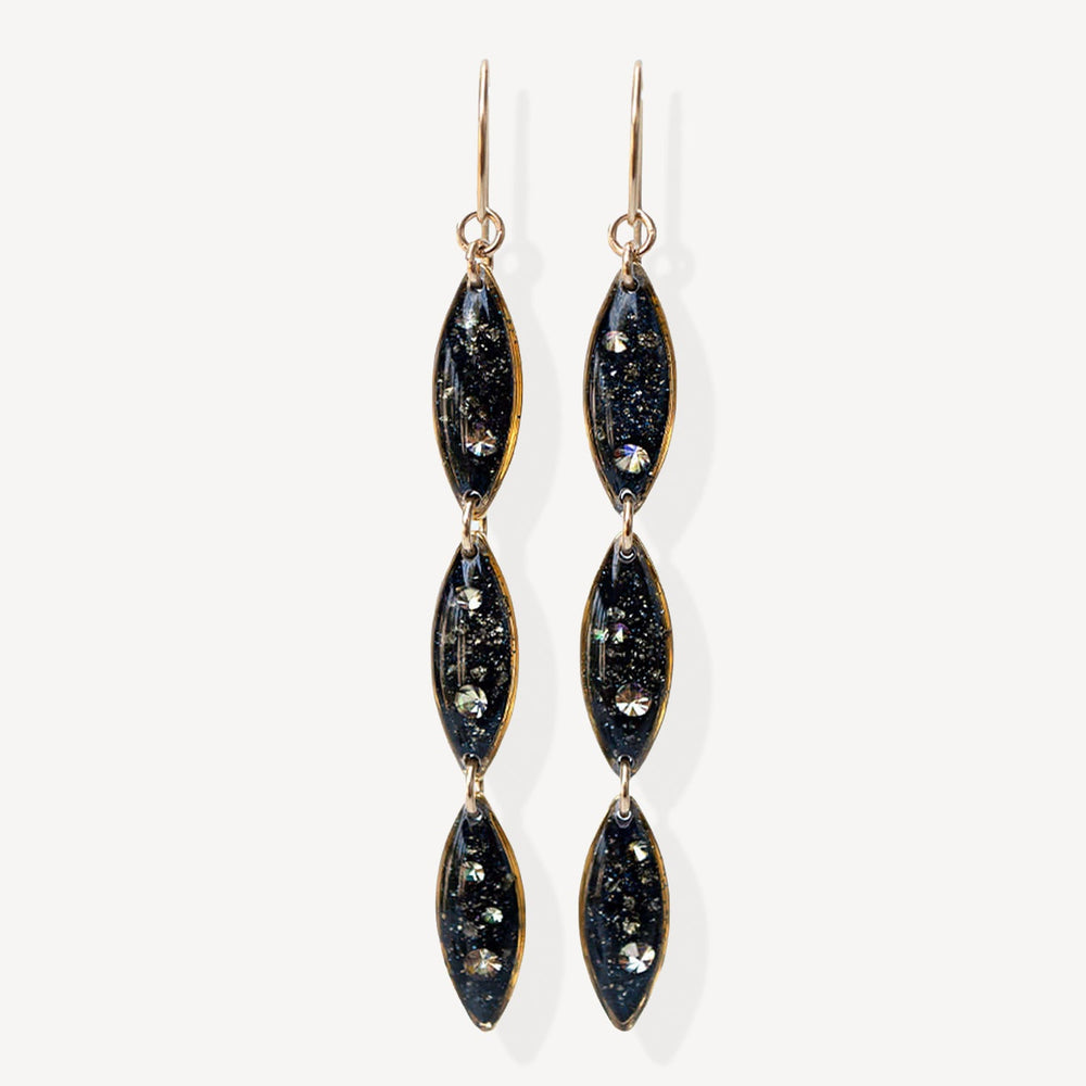 Pair of black and gold earrings on a white background