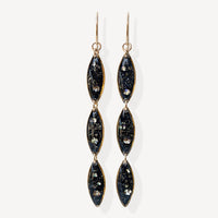 Pair of black and gold earrings on a white background