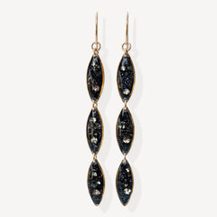 Pair of black and gold earrings on a white background